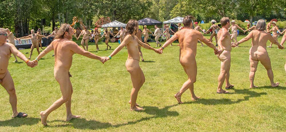 nude group holding hands walking in a circle